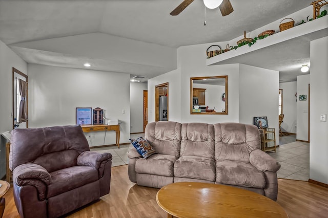 living room with light hardwood / wood-style floors, ceiling fan, and lofted ceiling