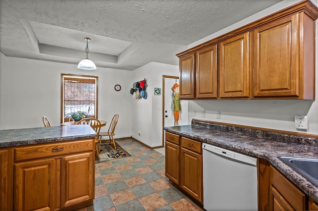 kitchen featuring sink, white dishwasher, decorative light fixtures, a textured ceiling, and a tray ceiling