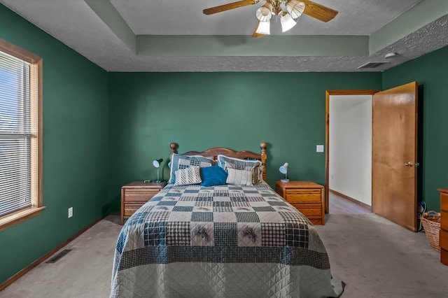 carpeted bedroom with a textured ceiling and ceiling fan