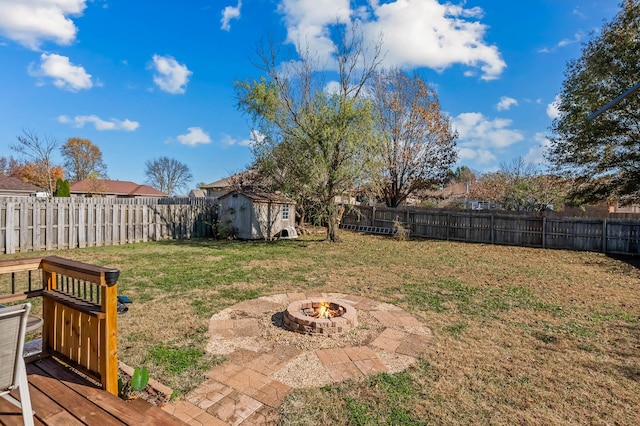 view of yard with a shed and an outdoor fire pit