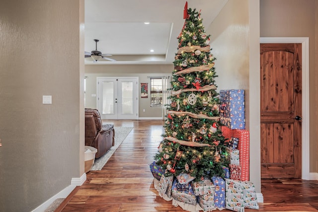 foyer with a tray ceiling, french doors, ceiling fan, wood finished floors, and baseboards