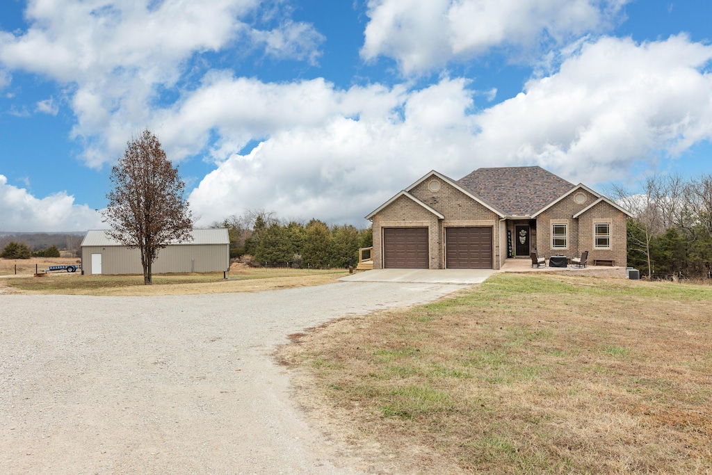 view of front of house with a garage, a front yard, concrete driveway, and brick siding