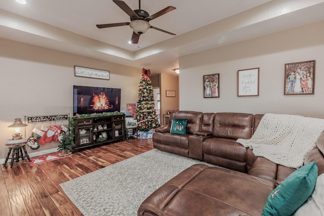 living room with baseboards, a ceiling fan, and wood finished floors