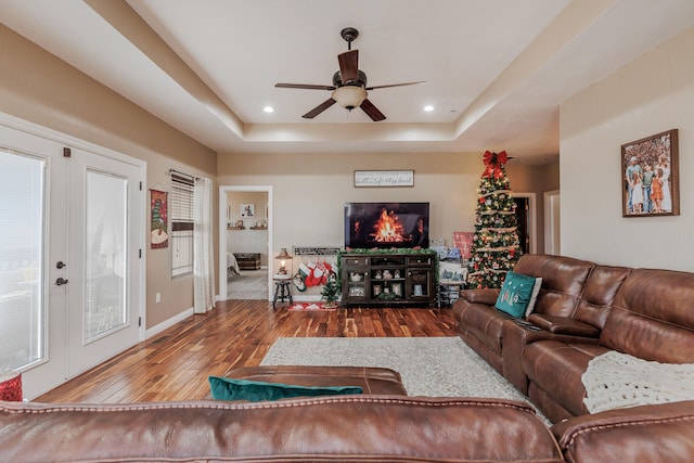 living room with french doors, recessed lighting, a raised ceiling, baseboards, and hardwood / wood-style flooring