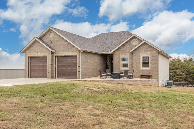 view of front of property with cooling unit, a garage, brick siding, driveway, and a front lawn