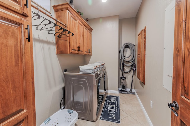 laundry room with cabinet space, independent washer and dryer, baseboards, and light tile patterned floors