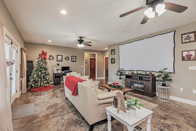 living area with baseboards, ceiling fan, a glass covered fireplace, and recessed lighting