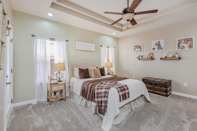 carpeted bedroom with ceiling fan, recessed lighting, a raised ceiling, and baseboards