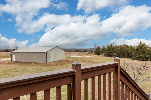 view of yard featuring a pole building, a rural view, an outdoor structure, and fence