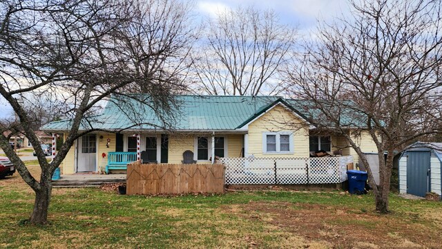 ranch-style house with a front yard, a porch, and a storage unit