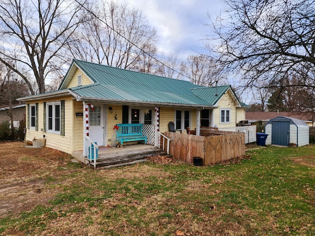 view of front of property featuring a front yard, a porch, and a storage unit