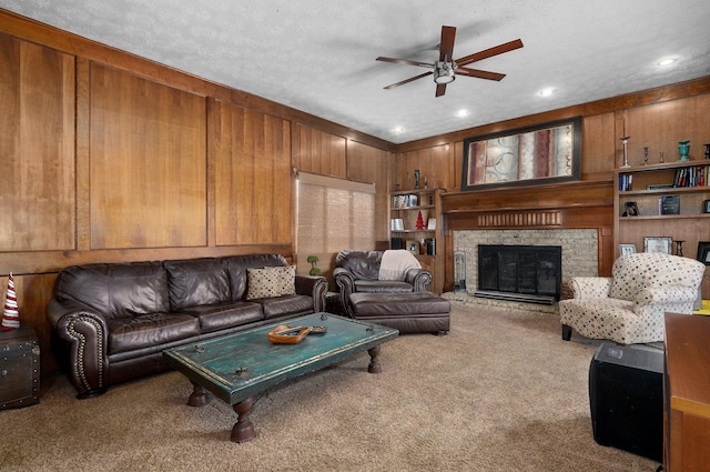 living room with carpet, wood walls, and a textured ceiling