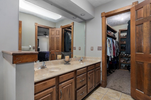 bathroom featuring a textured ceiling, vanity, tile patterned floors, and ceiling fan