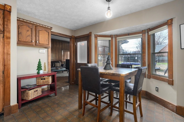 dining space with dark tile patterned flooring and a textured ceiling