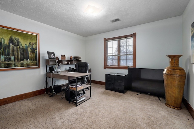 carpeted home office featuring a textured ceiling