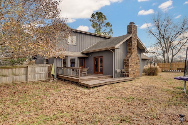 rear view of house with a trampoline and a wooden deck