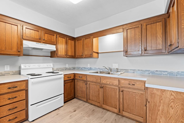 127 N Walnut St, Blue Eye, MO 65611 - kitchen featuring white electric stove, under cabinet range hood, brown cabinetry, light wood-style flooring, and light countertops