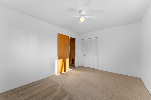 unfurnished bedroom featuring ceiling fan, a closet, and carpet