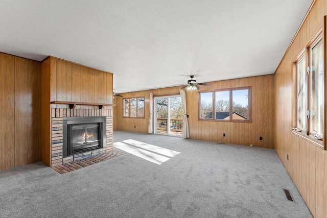 127 N Walnut St, Blue Eye, MO 65611 - unfurnished living room with a brick fireplace, carpet, ceiling fan, and wooden walls