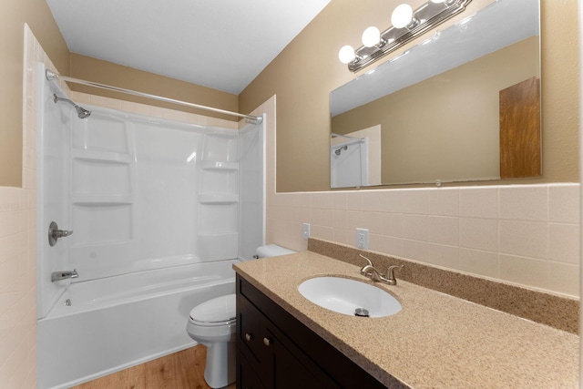 full bathroom featuring vanity, toilet, tile walls, wood-type flooring, and tub / shower combination