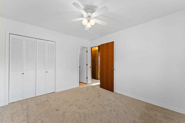 unfurnished bedroom featuring light carpet, a closet, and ceiling fan