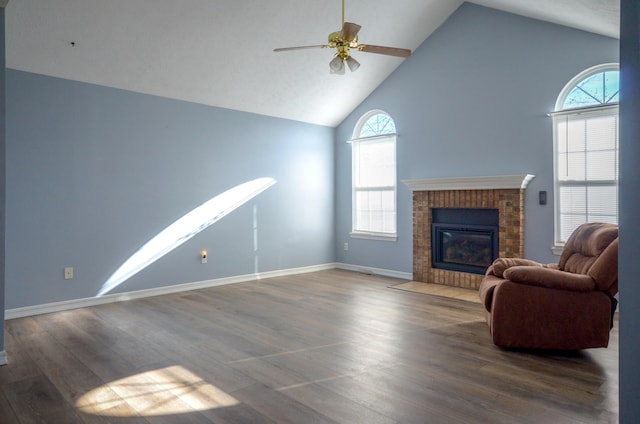 unfurnished living room featuring plenty of natural light, a fireplace, dark wood-type flooring, and high vaulted ceiling