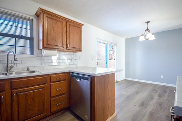 kitchen with kitchen peninsula, light wood-type flooring, sink, decorative light fixtures, and dishwasher