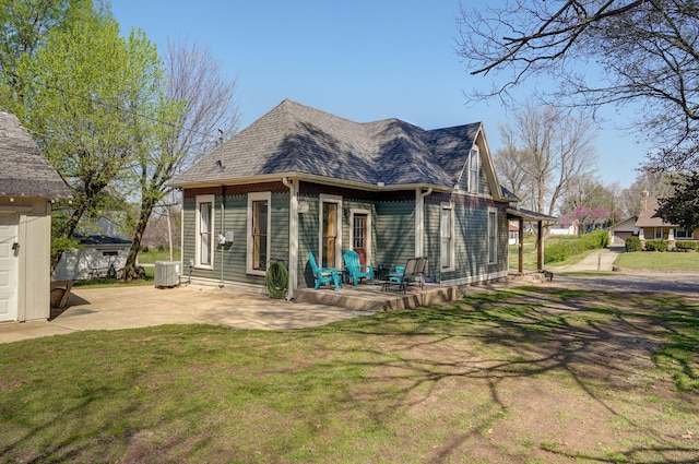 rear view of property with a patio, central AC unit, and a lawn