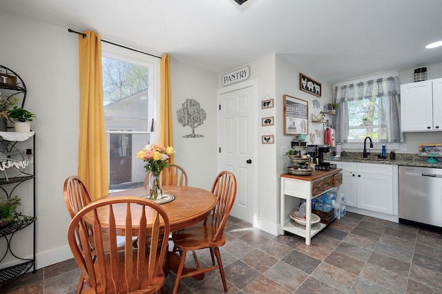 dining room with baseboards and stone finish flooring