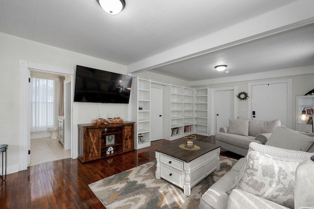 living area with wood-type flooring and beamed ceiling