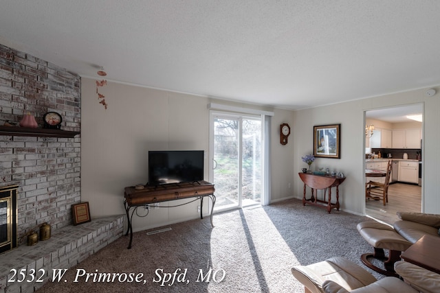 living room featuring light colored carpet, ornamental molding, a textured ceiling, and a brick fireplace