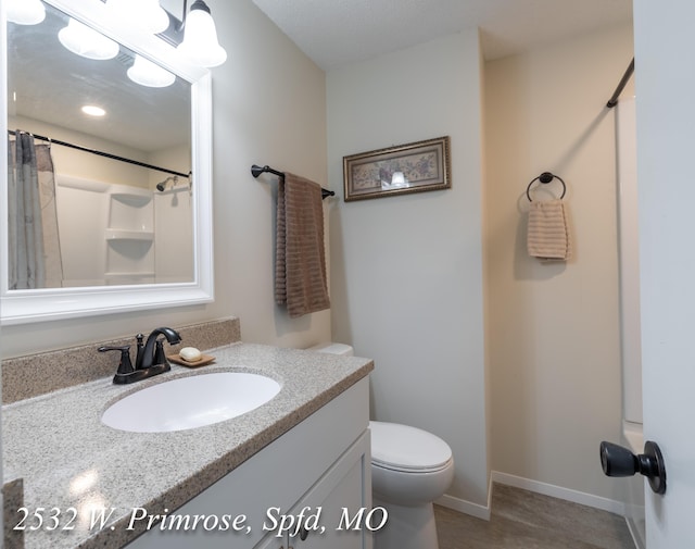 bathroom with a shower, vanity, and toilet