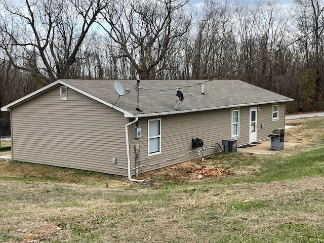 rear view of property with a yard and central air condition unit