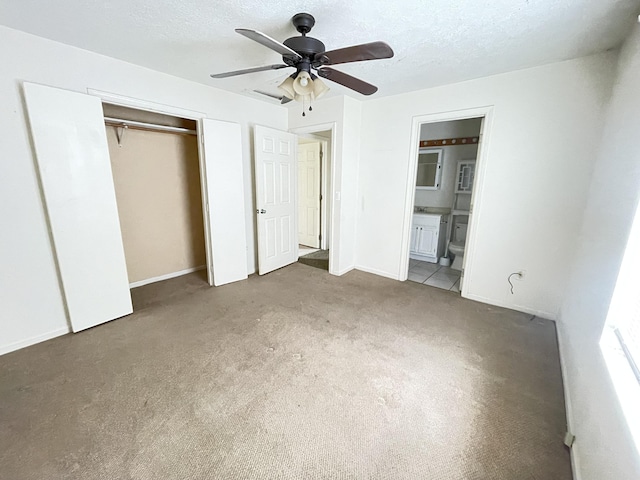 unfurnished bedroom featuring ensuite bath, ceiling fan, carpet, and a textured ceiling