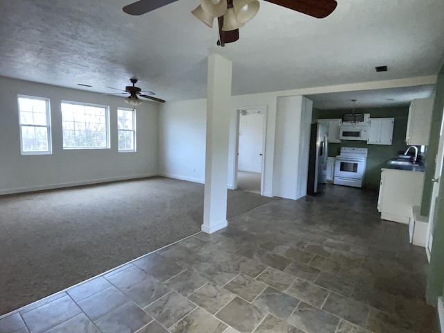 unfurnished living room featuring carpet and sink