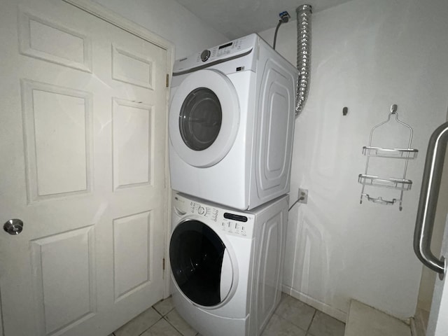 laundry area featuring light tile patterned floors and stacked washer and clothes dryer