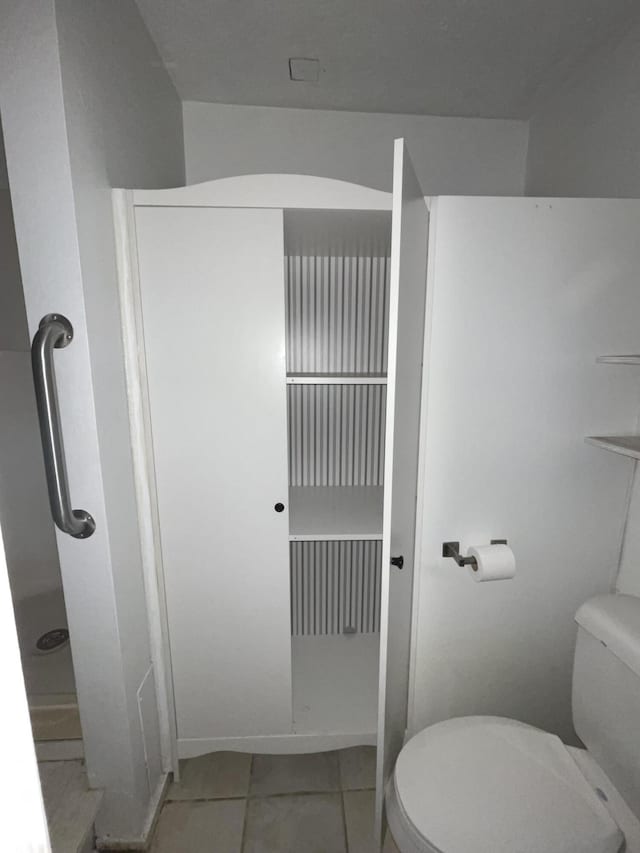 bathroom with toilet and tile patterned floors