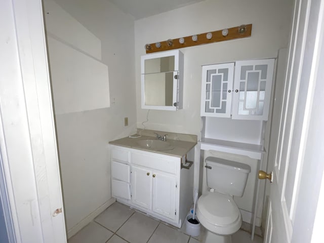 bathroom with toilet, vanity, and tile patterned floors