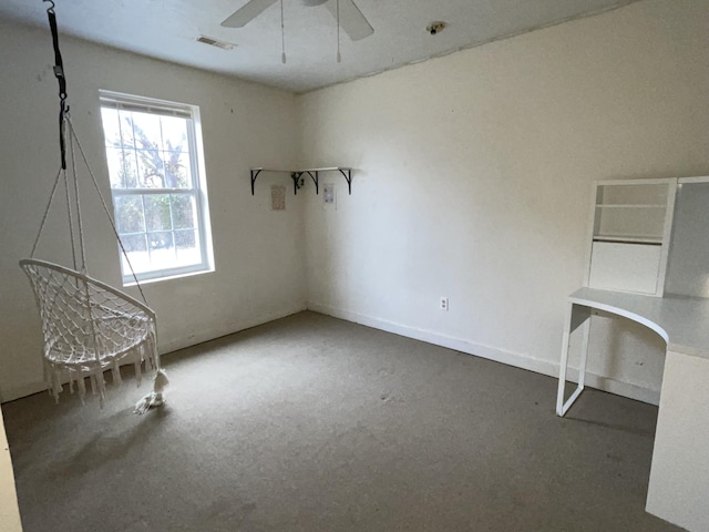 unfurnished office with ceiling fan and carpet