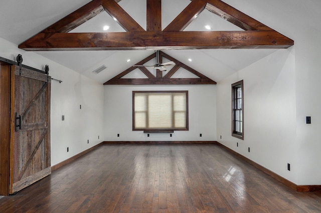 unfurnished room featuring a wealth of natural light, a barn door, visible vents, and hardwood / wood-style floors