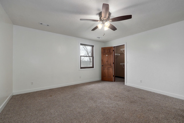 spare room with baseboards, visible vents, a textured ceiling, and carpet flooring