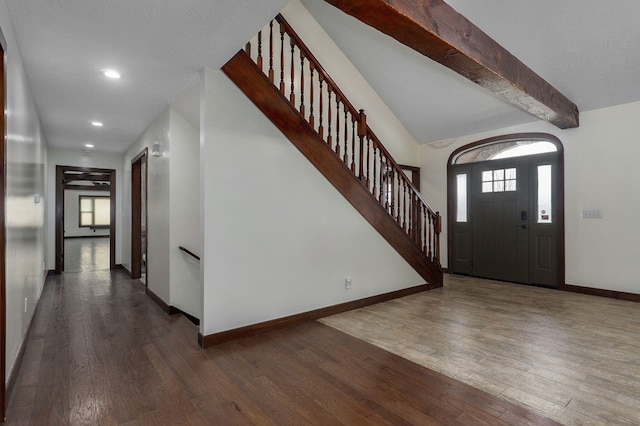 foyer featuring baseboards, wood finished floors, and a healthy amount of sunlight