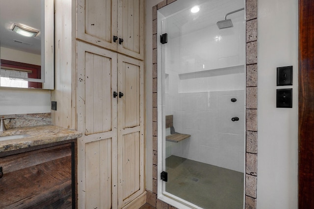 bathroom with a stall shower, visible vents, and vanity