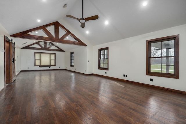 unfurnished living room featuring a ceiling fan, hardwood / wood-style flooring, baseboards, and a barn door