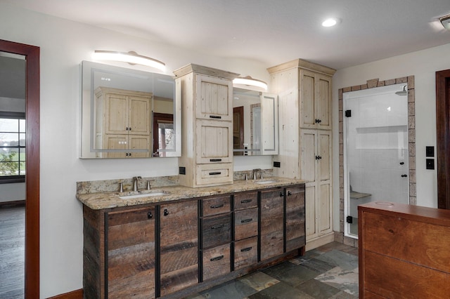 bathroom featuring double vanity, stone finish flooring, and a sink