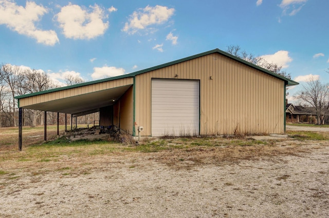 garage with driveway and a detached garage