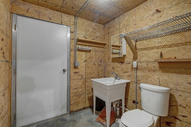 bathroom with toilet and unfinished concrete flooring