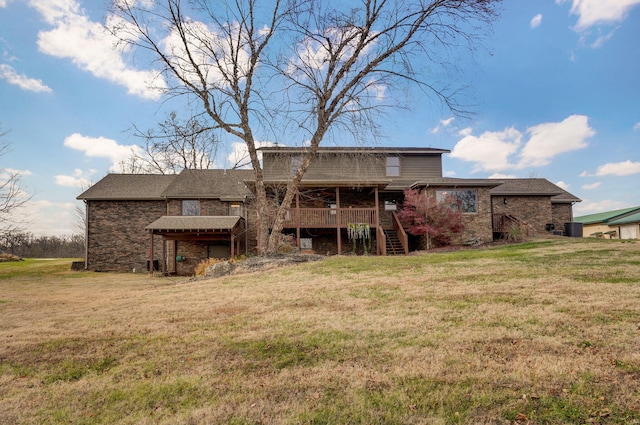 rear view of property with a lawn, stairway, and a wooden deck