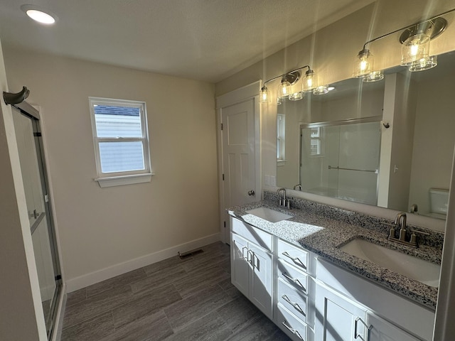 bathroom featuring hardwood / wood-style flooring, vanity, and walk in shower