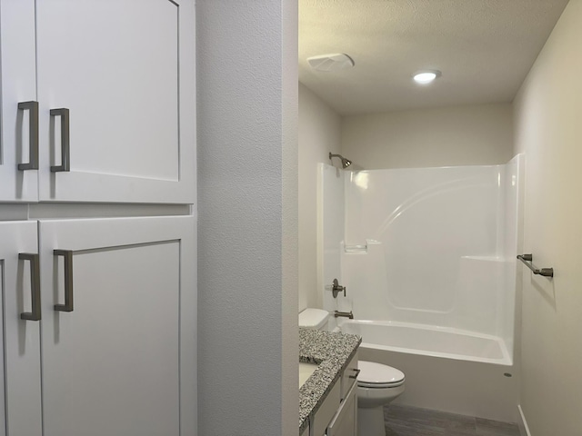 full bathroom featuring hardwood / wood-style floors, vanity, toilet, a textured ceiling, and tub / shower combination